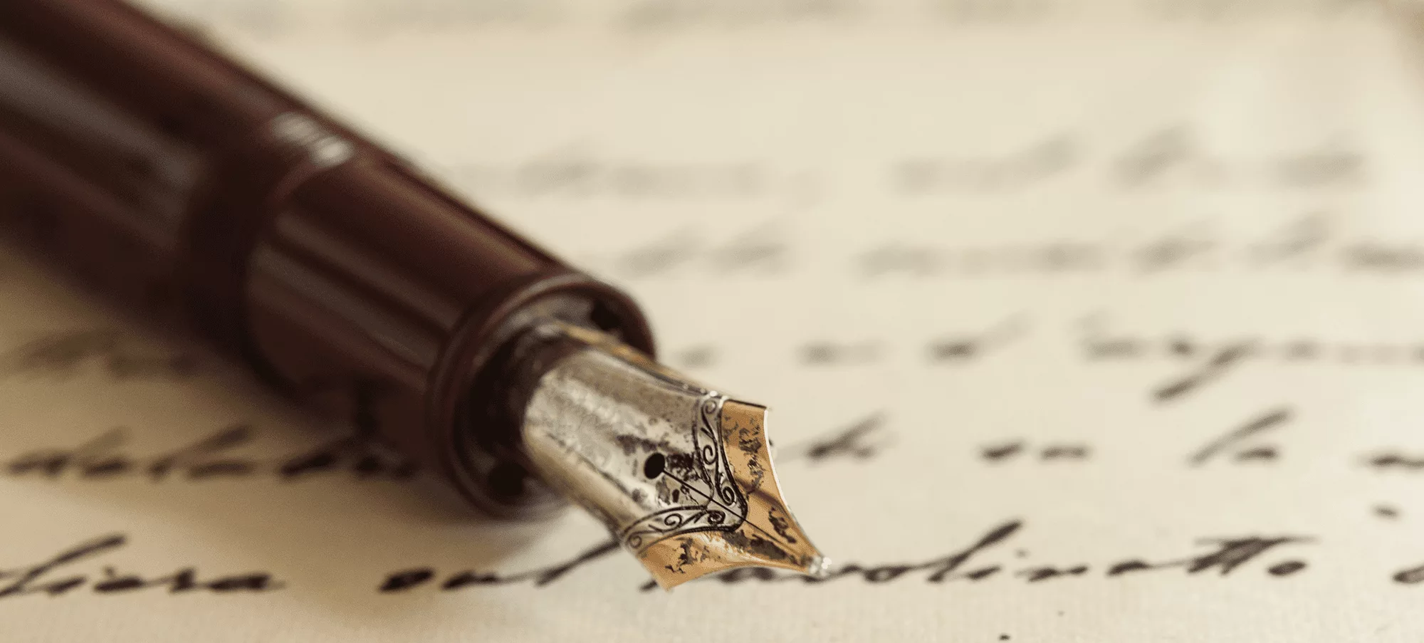 A quill pen rests over several lines of cursive writing.